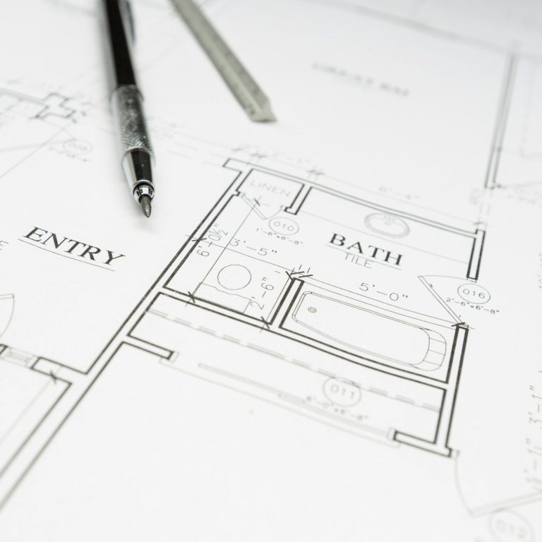 Grundriss eines Hauses mit Eingangsbereich und Badezimmer, Stift daneben.